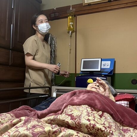 腹膜透析中の利用者と訪問看護師の笑顔（在宅医療・透析サポート）